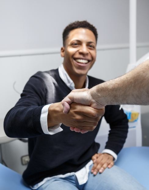 Shaking hands with dentist during dental checkup and teeth cleaning visit