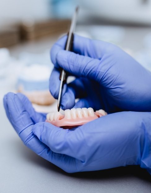 Dental lab technician crafting denture