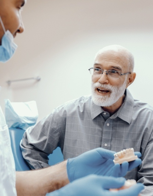 Man with dentures talking to dentist
