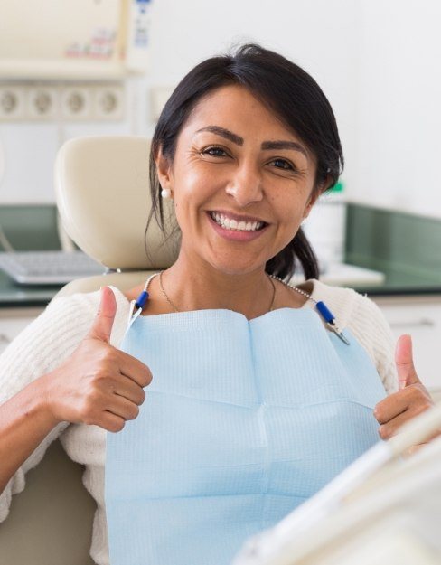 Woman giving thumbs up during dental office visit