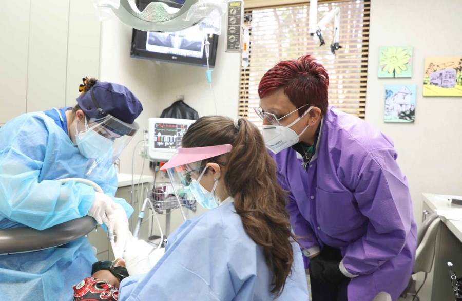 Three dental professionals treating a patient in Houston
