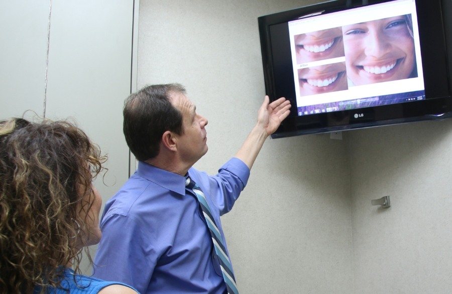 Houston dentist showing a patient his smile gallery on a screen