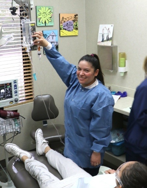 Dental team member setting up I V sedation dentistry drip before wisdom tooth extractions