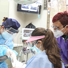 Dental team members treating dental patient