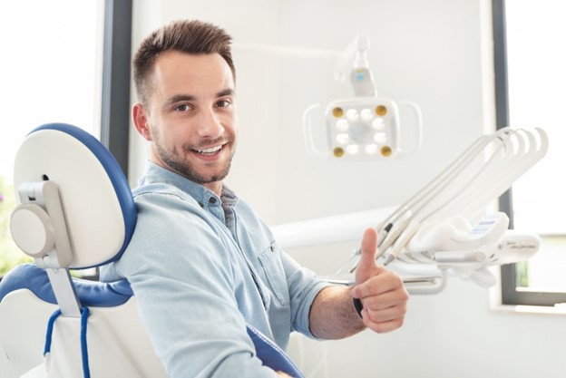 Man at the dentist giving a thumb’s up.