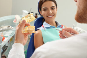 A woman smiling while a dentist talks to her about a sinus lift procedure