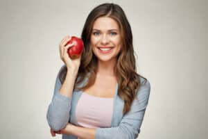 Woman with beautiful smile holding an apple