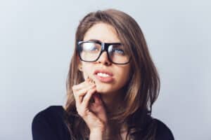 Woman with distressed look holding her cheek due to pain from gum disease.