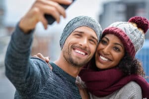 Couple with beautiful, white teeth taking photos during holiday travels