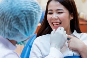 Happy patient smiling at dentist after getting dental crowns