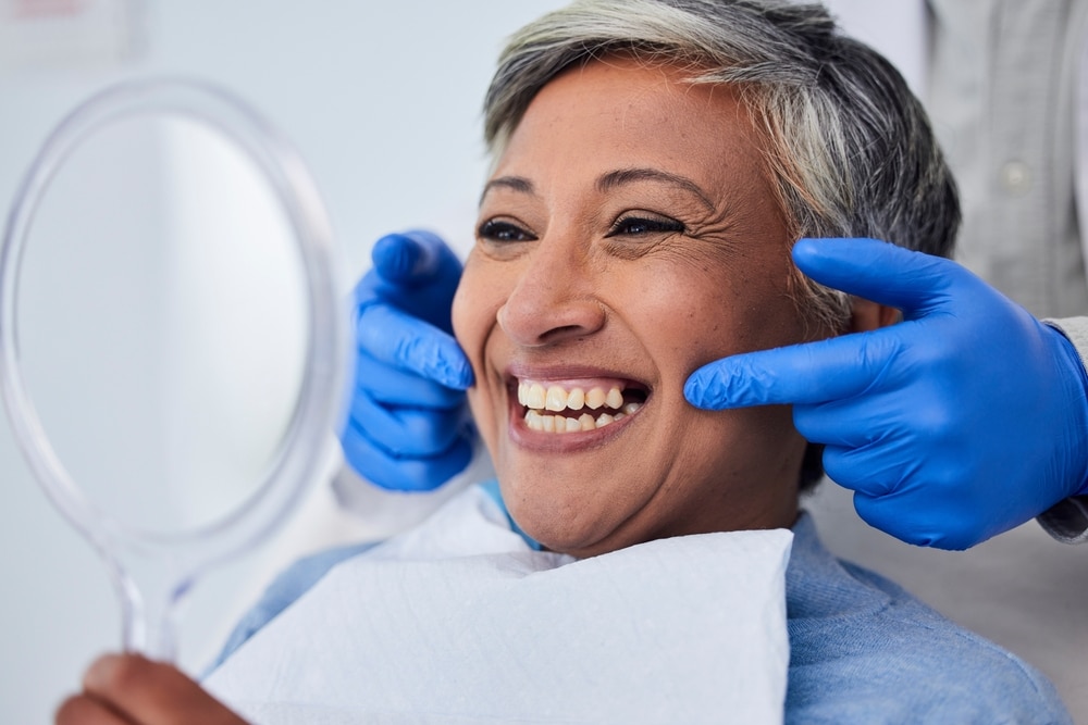 Woman with a big, bright smile after receiving dental bonding treatment to correct tooth imperfections.