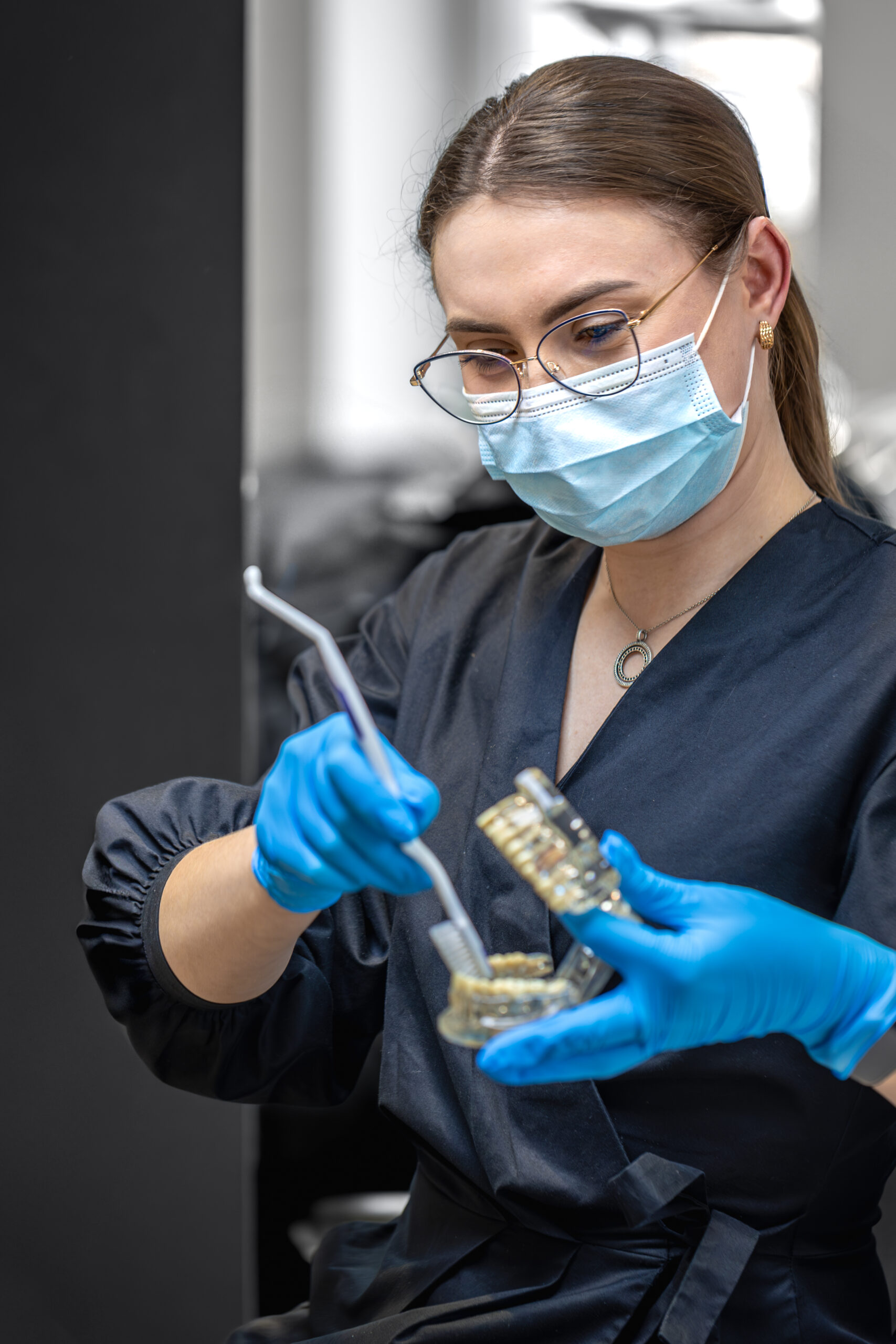 Female dentist holding dental model in hands. Concept of dentistry and dental treatment.