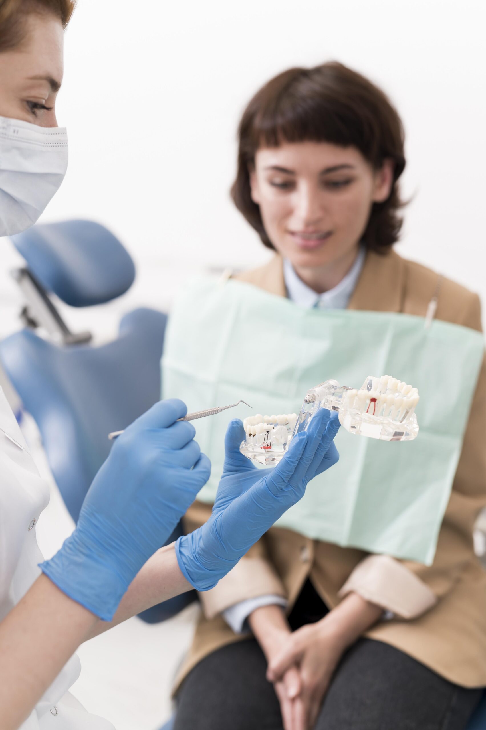 female patient looking dental mold with orthodontist