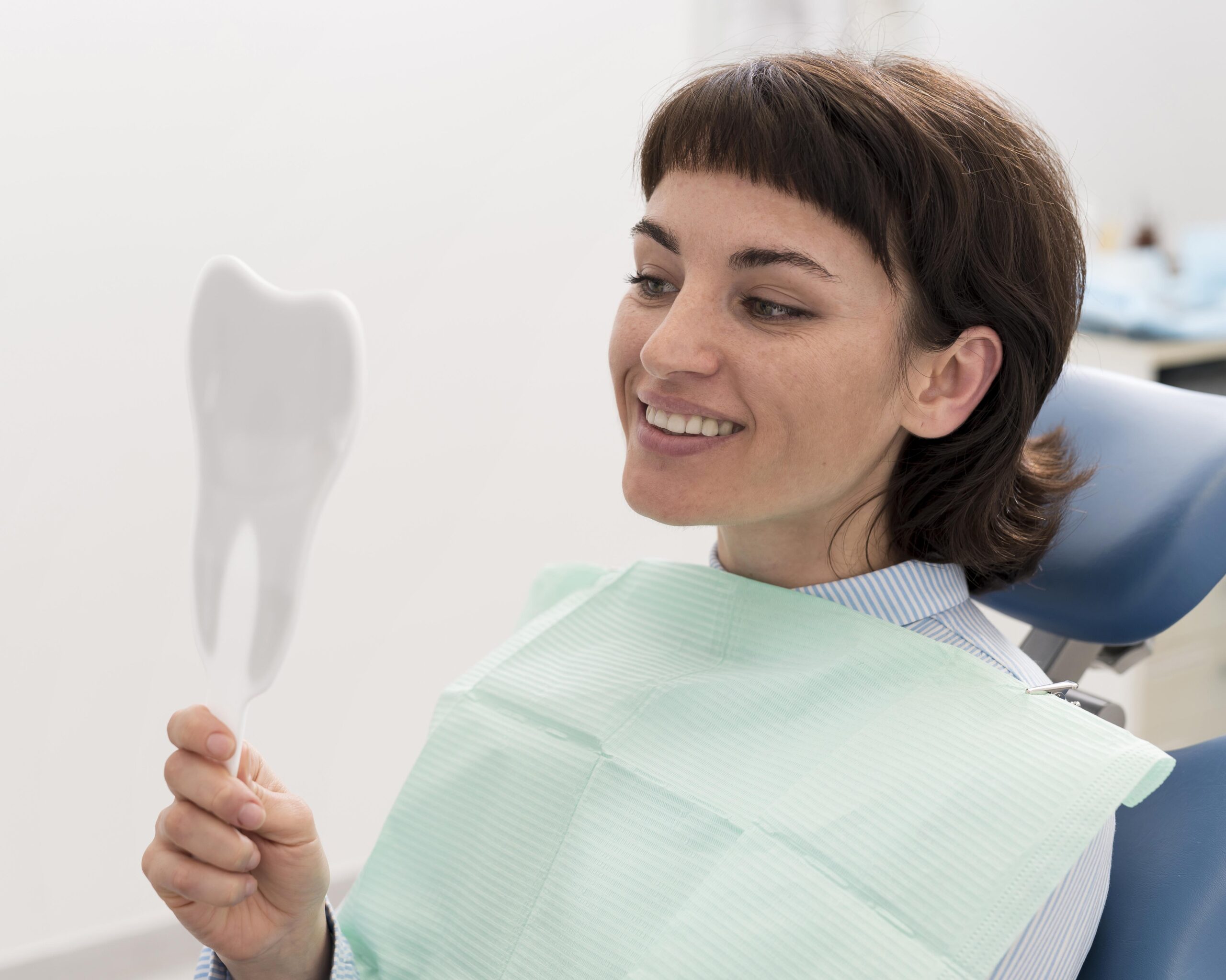 female patient looking mirror after dental procedure