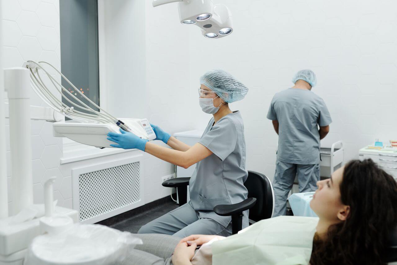 Dental professionals in a modern clinic preparing for an oral surgery for a female patient