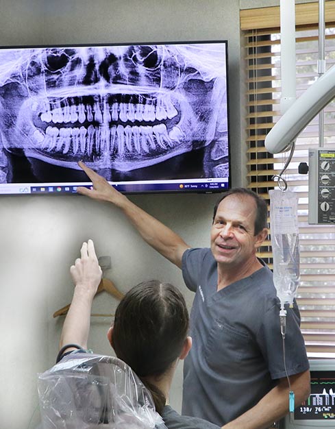Patient and dentist discussing extraction while looking at x-ray.